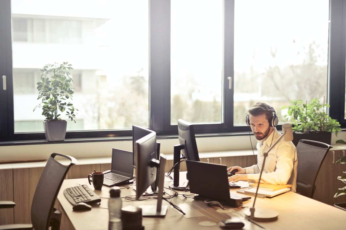 IT technician with a headset at a help desk in a bright office